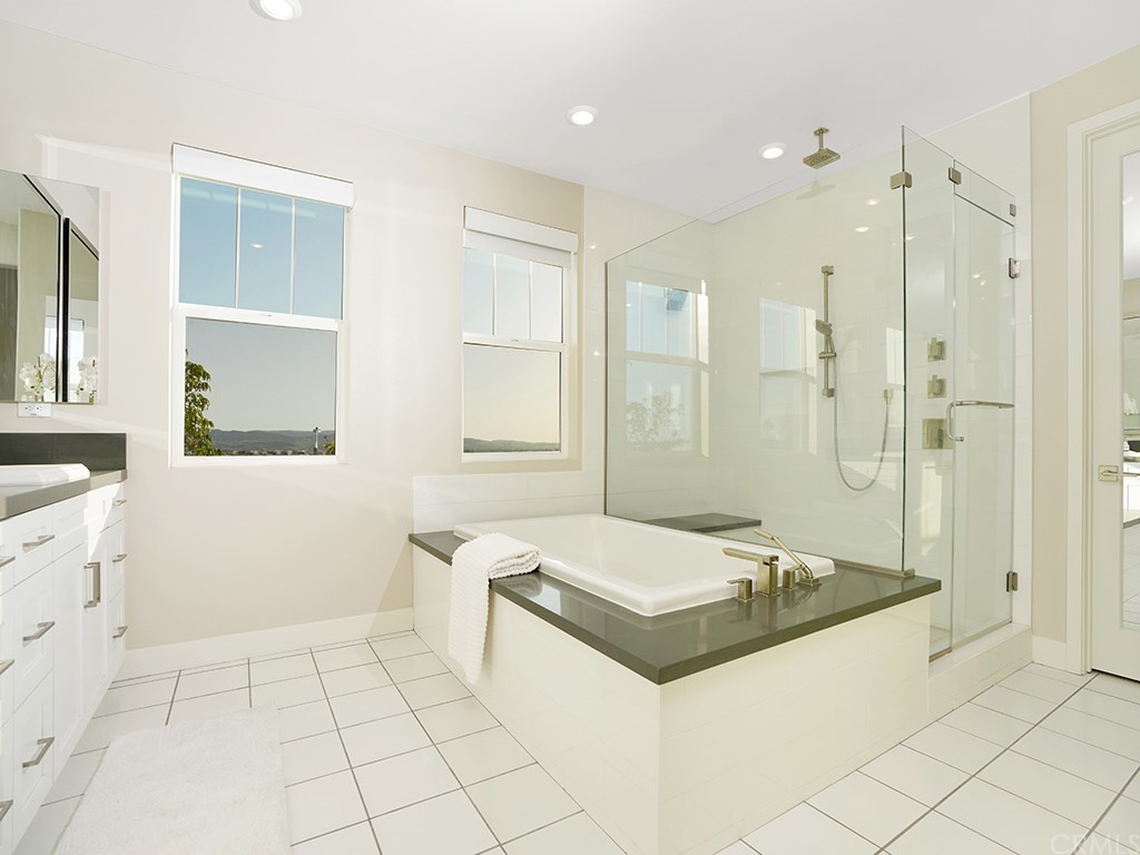 92 Iluna Irvine, CA 92618 - Photo 25 of 45 a bathroom with a tub a sink a mirror and a shower