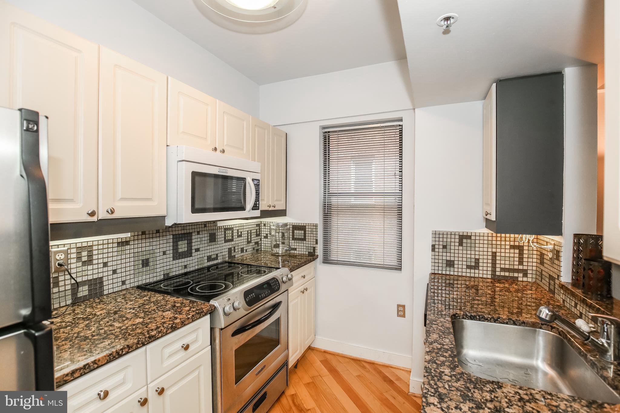 1727 R Street Northwest, Unit 203 Washington, DC 20009 - Photo 8 of 14 a kitchen with stainless steel appliances granite countertop a sink stove and cabinets