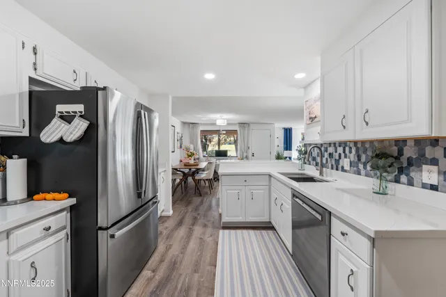 a kitchen with white cabinets and stainless steel appliances