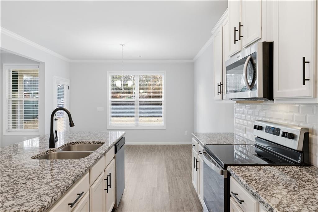 3244 Hawthorne Path Braselton, GA 30517 - Photo 14 of 48 a kitchen with granite countertop a stove sink and microwave
