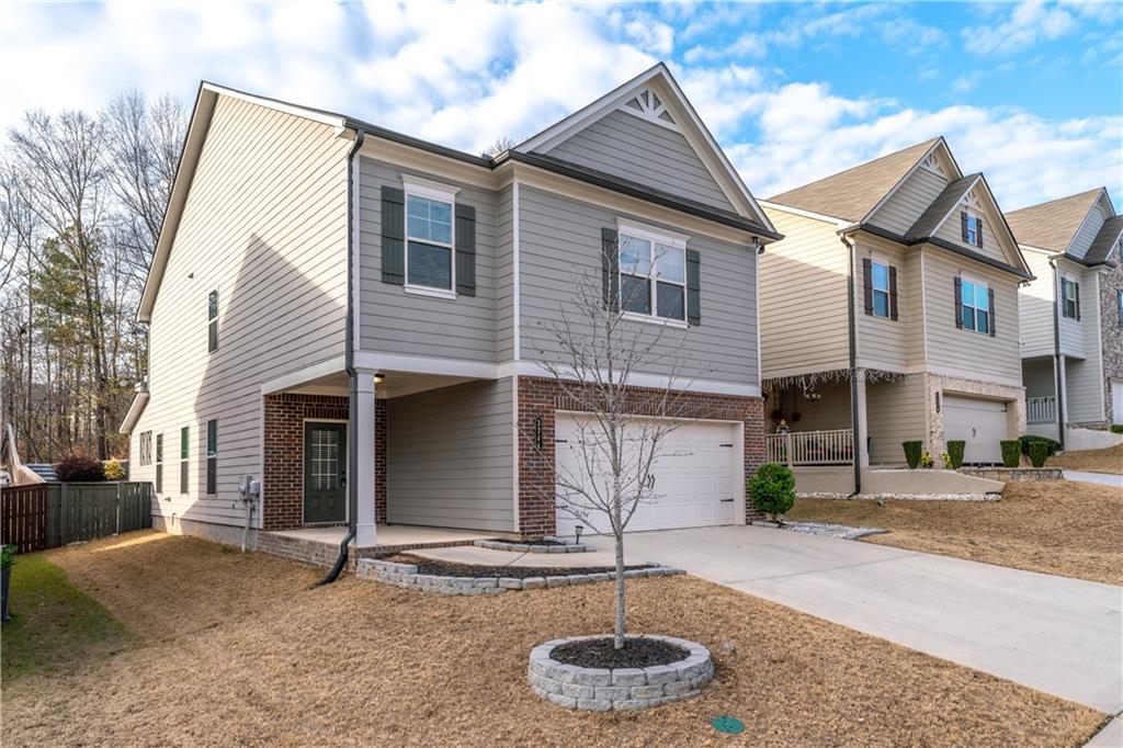 3244 Hawthorne Path Braselton, GA 30517 - Photo 2 of 48 a front view of a house with garden and garage