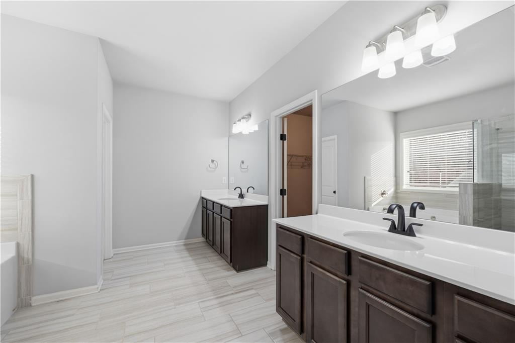 3244 Hawthorne Path Braselton, GA 30517 - Photo 29 of 48 a spacious bathroom with a double vanity sink a mirror and a shower