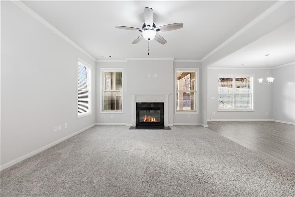 3244 Hawthorne Path Braselton, GA 30517 - Photo 6 of 48 an empty room with windows and fireplace
