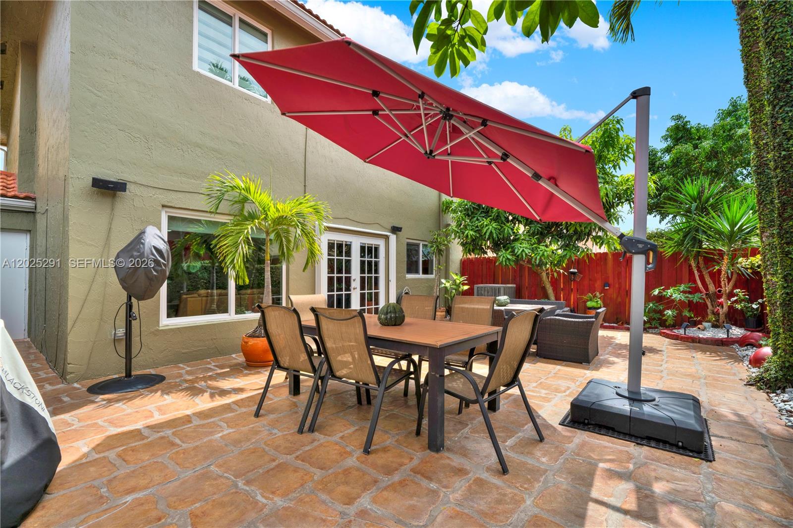 10006 Southwest 162nd Path Miami, FL 33196 - Photo 33 of 40 a view of a patio with a table and chairs under an umbrella