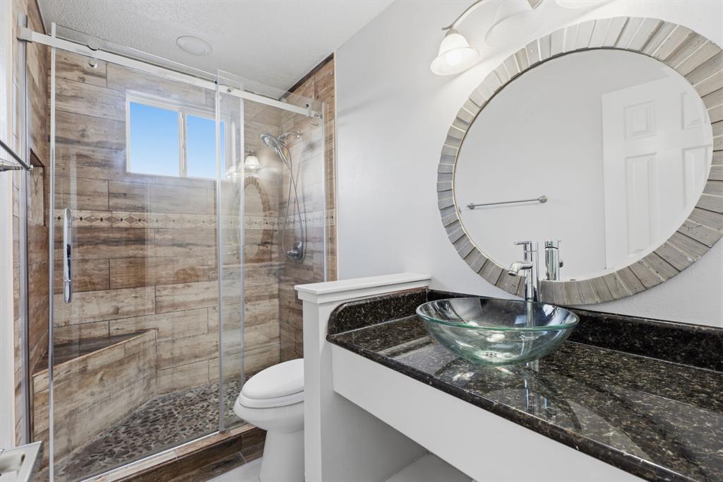3721 Smartt Street Rowlett, TX 75088 - Photo 20 of 27 a bathroom with a sink a toilet and a mirror