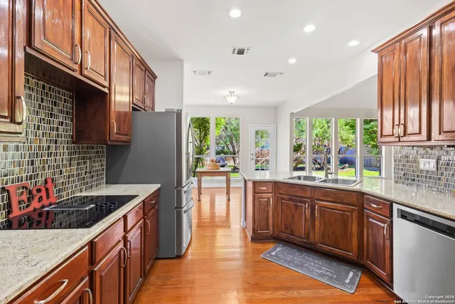 a kitchen with stainless steel appliances granite countertop sink stove top oven and cabinets