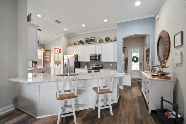a kitchen with white cabinets and stainless steel appliances