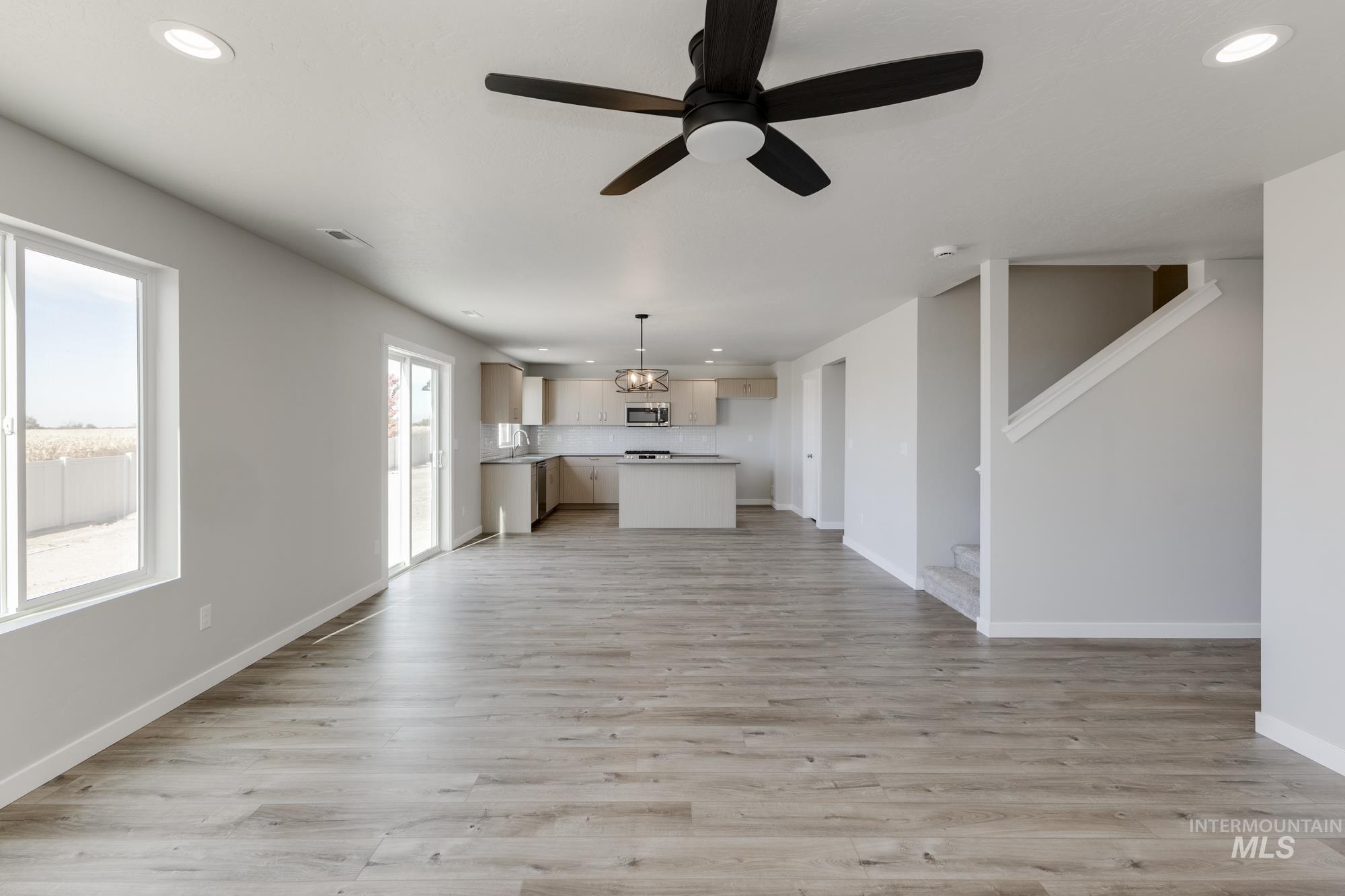 12853 Decatur Street Nampa, ID 83651 - Photo 10 of 24 Spacious open-concept living area featuring wood-finish flooring, a contemporary ceiling fan, and recessed lighting