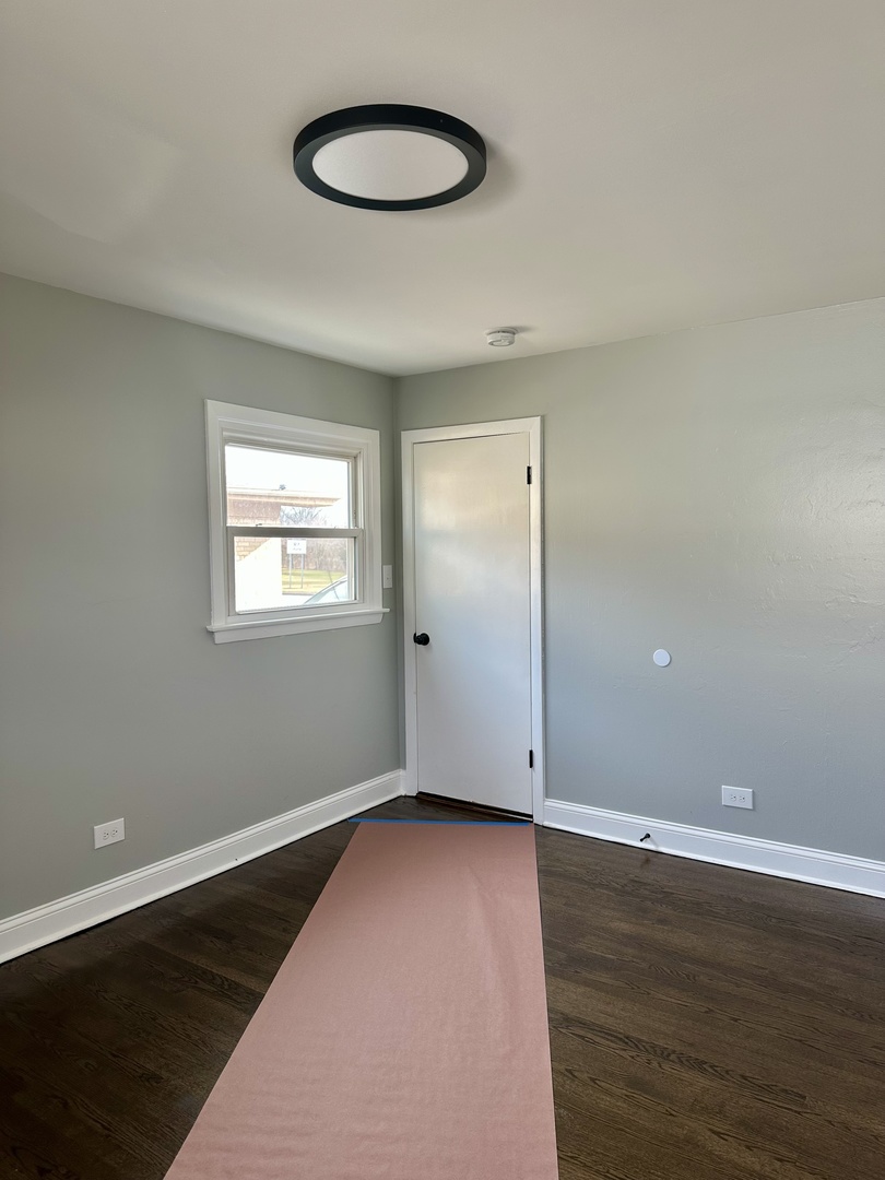 Undisclosed Address Glenwood, IL 60425 - Photo 11 of 17 an empty room with wooden floor and windows