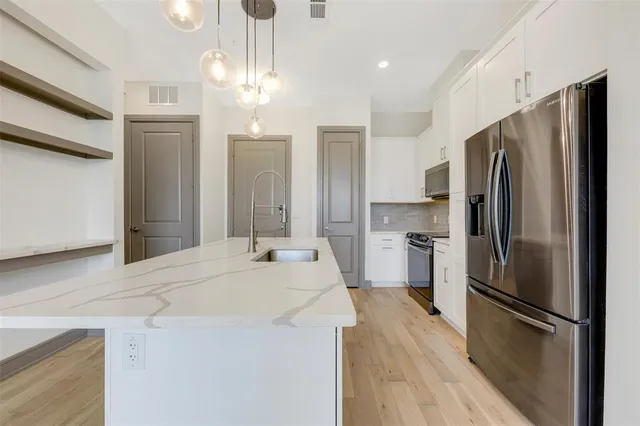 a kitchen with stainless steel appliances a refrigerator sink and microwave