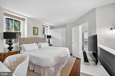 a spacious bedroom with a bed a couch and a window