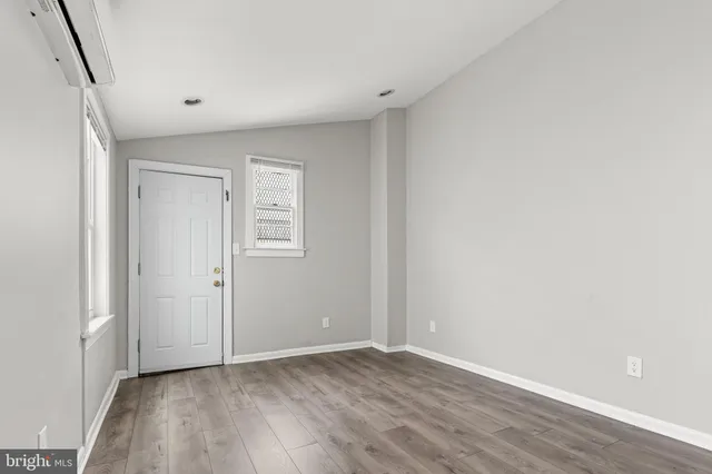 a view of an empty room with closet and a window