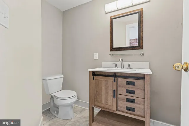 a bathroom with a toilet sink and mirror