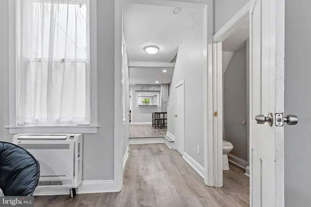 a view of a hallway with wooden floor and closet area