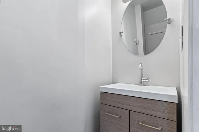 a bathroom with a sink vanity and mirror