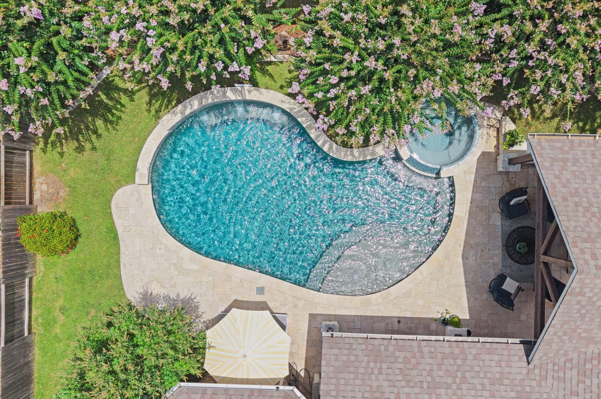 9507 Empress Crossing Drive Spring, TX 77379 - Photo 47 of 50 This aerial photo showcases a beautifully landscaped backyard featuring a kidney-shaped pool with adjacent hot tub, surrounded by lush greenery and a stone patio. Ideal for relaxing and entertaining.