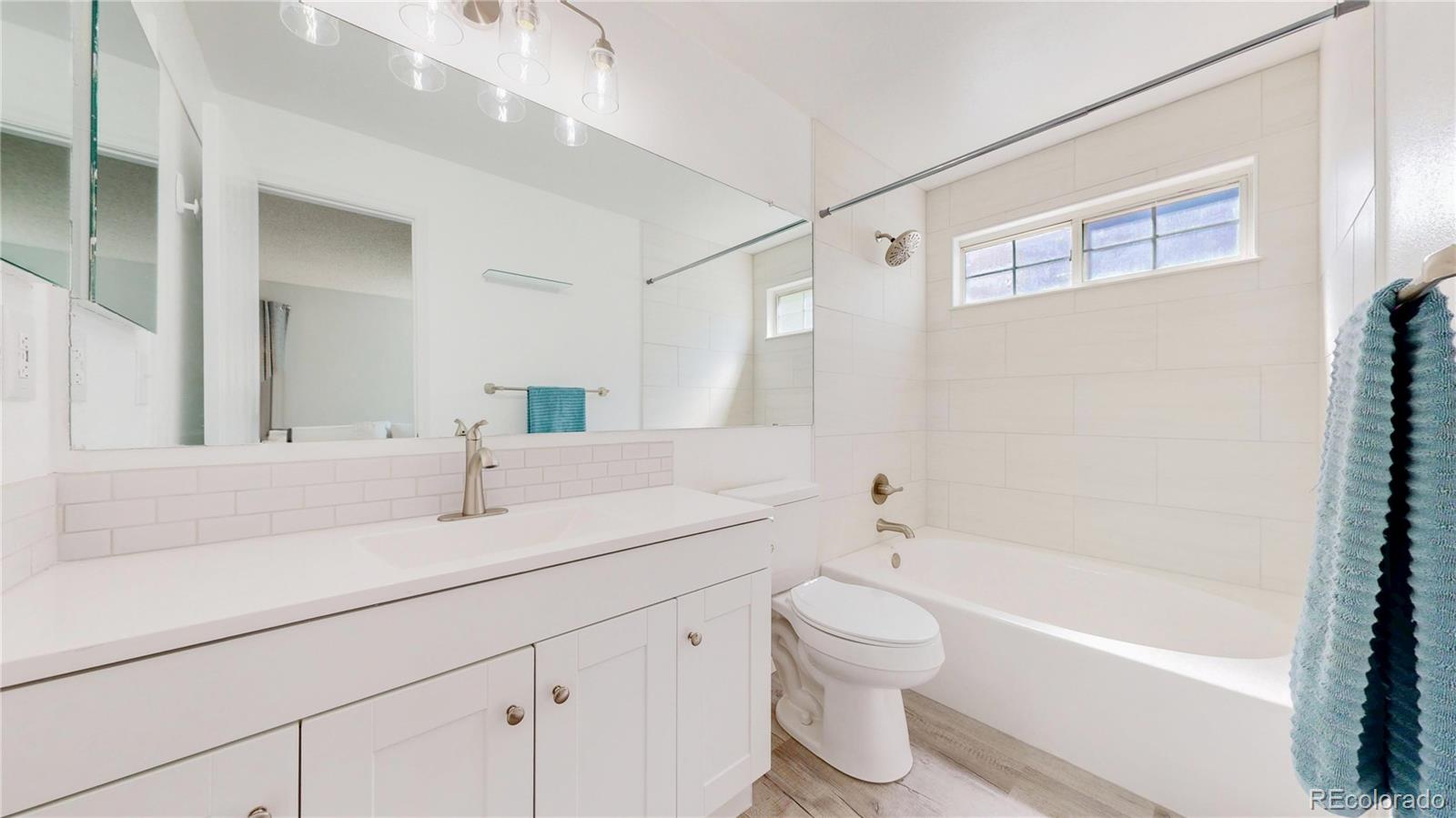 3663 South Flanders Street Aurora, CO 80013 - Photo 12 of 31 a bathroom with a sink a toilet and a bathtub