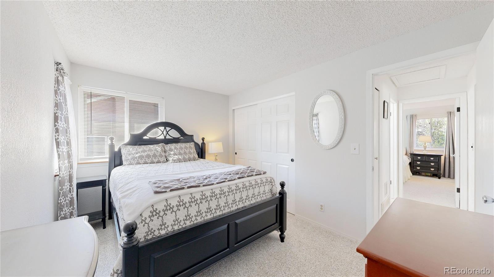 3663 South Flanders Street Aurora, CO 80013 - Photo 13 of 31 a bedroom with a large bed and a chandelier