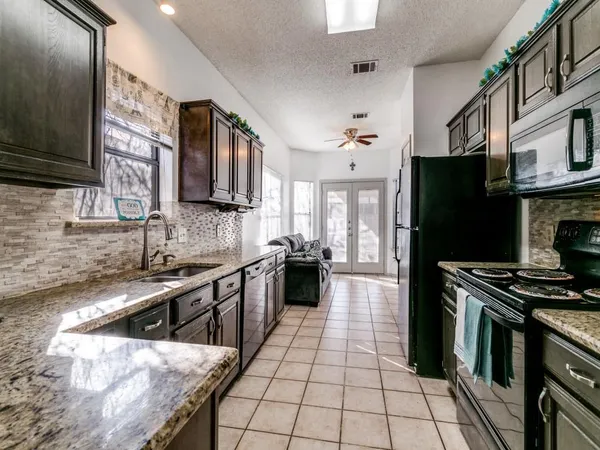 a kitchen with stainless steel appliances granite countertop a stove a sink and a refrigerator