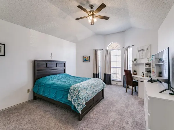 a bedroom with a bed furniture and a flat screen tv