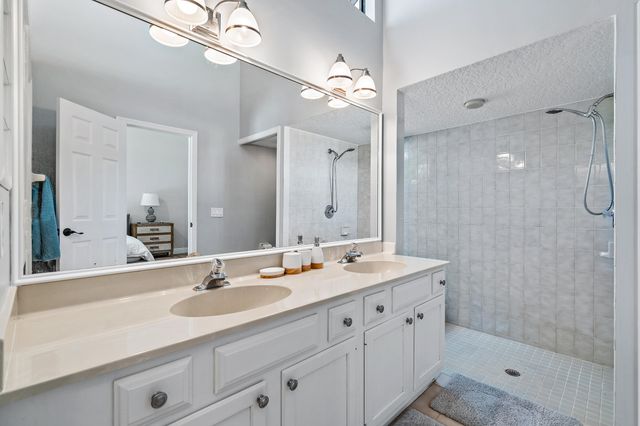 a bathroom with a shower sink double vanity and mirror