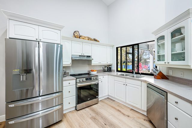 a kitchen with stainless steel appliances a stove sink and refrigerator