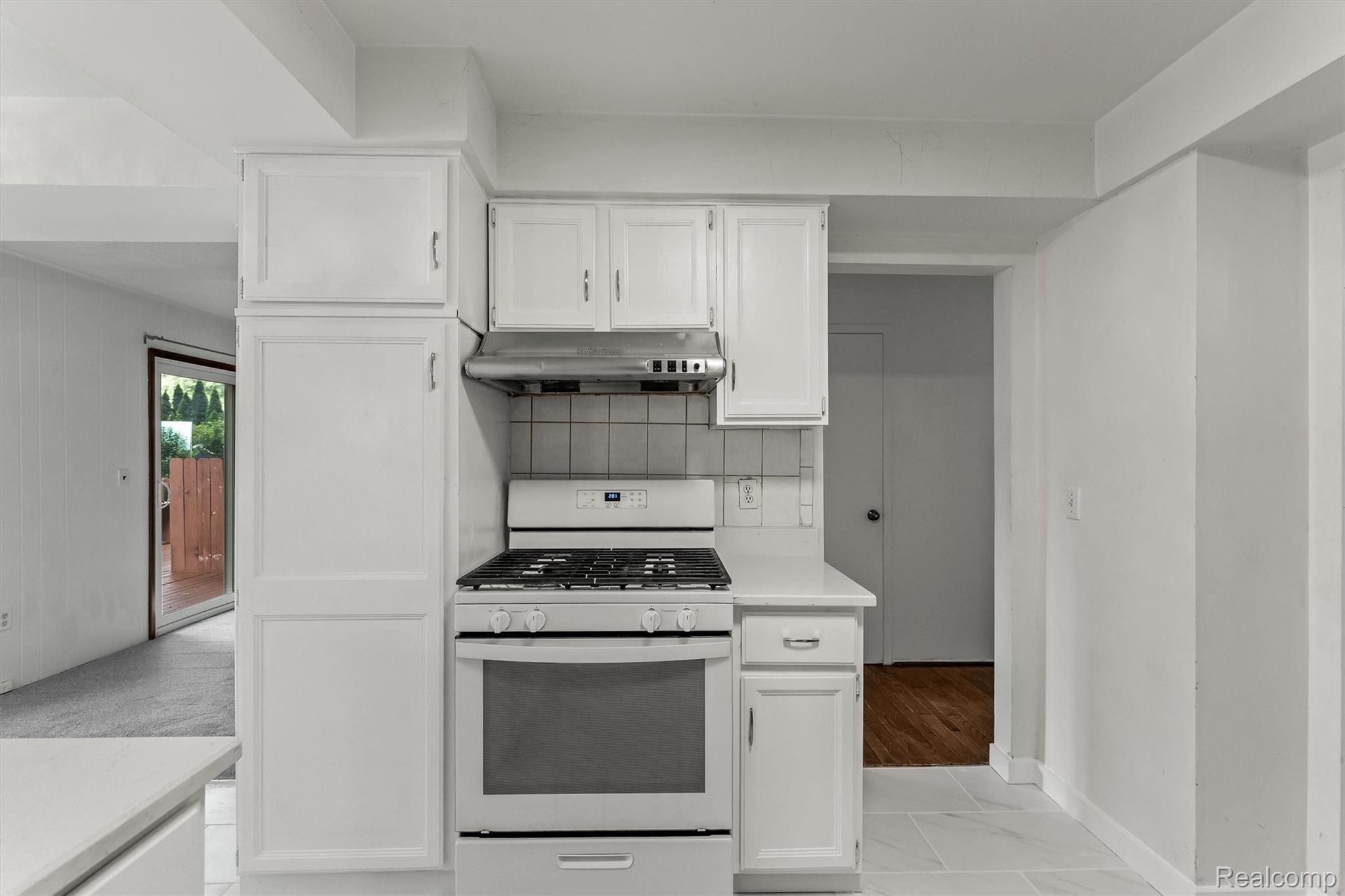 2118 Rutgers Drive Troy, MI 48085 - Photo 10 of 39 Kitchen featuring white cabinetry, a white gas range with oven, a matching range hood, and a tiled backsplash