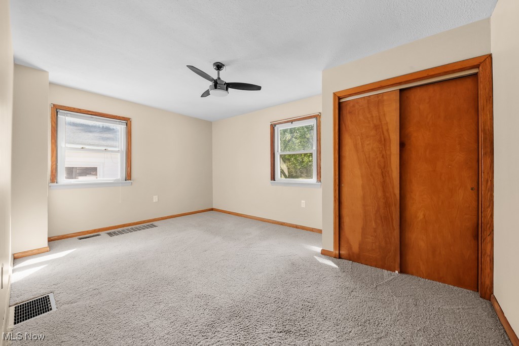 1702 Far View Road Akron, OH 44312 - Photo 19 of 49 Unfurnished bedroom with a closet, carpet, and ceiling fan