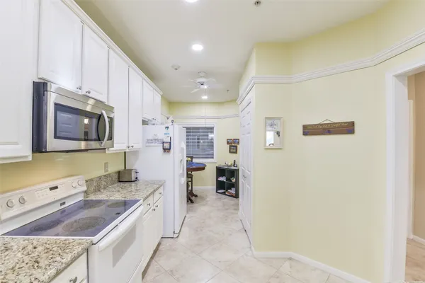 a large kitchen with stainless steel appliances granite countertop a lot of counter space and wooden floor