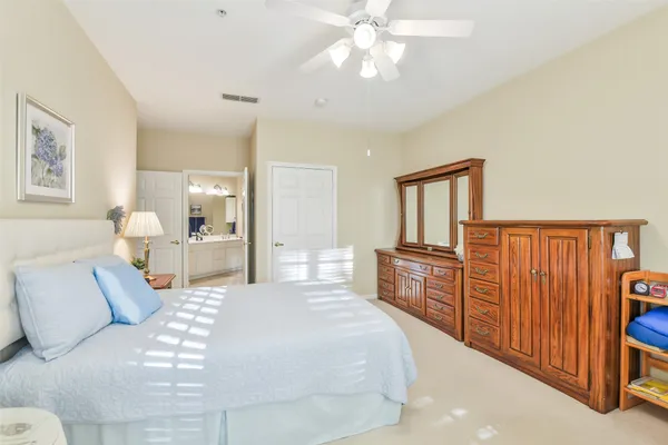 a bedroom with a large bed and a chandelier