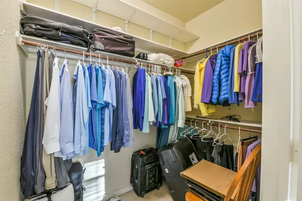 a view of walk in closet with clothes and shoes