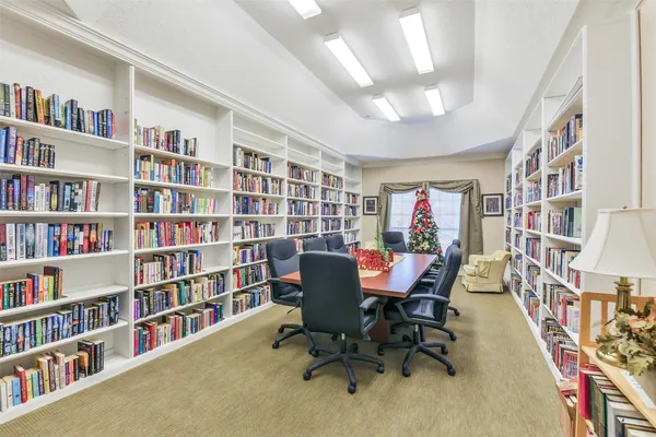 a view of a livingroom with a bookshelf and a dining room