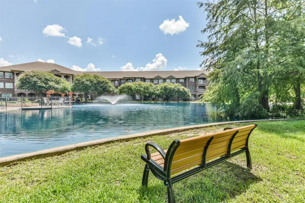 a view of a lake with couches and wooden fence