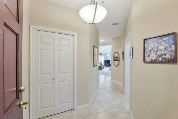 a view of a hallway with wooden floor and chandelier