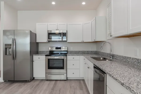 a kitchen with stainless steel appliances granite countertop a sink stove and refrigerator