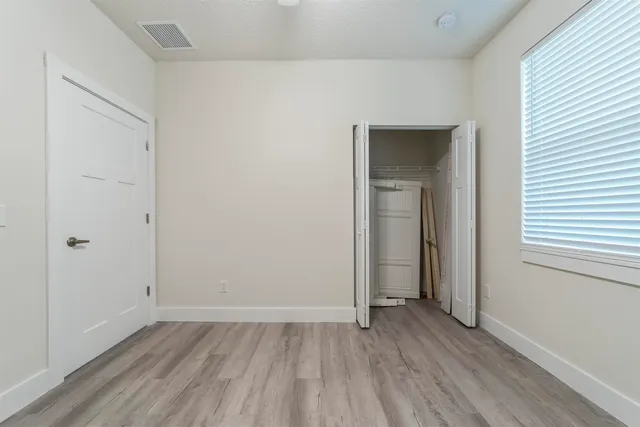 a view of an empty room with closet and a window