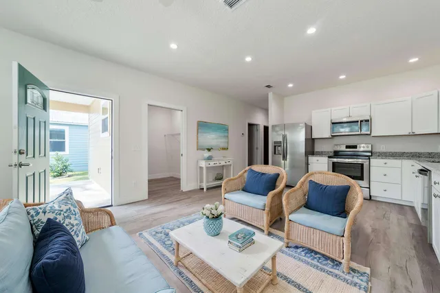 a living room with furniture and a view of kitchen