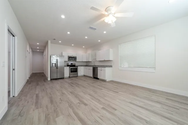 a view of a kitchen with a sink and a refrigerator