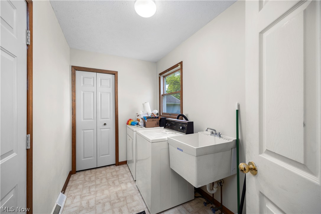 722 Jaycox Road Avon Lake, OH 44012 - Photo 20 of 48 Main floor Utility room featuring a built-in sink, window with outdoor scenery, ceiling-mounted light fixture, and storage
