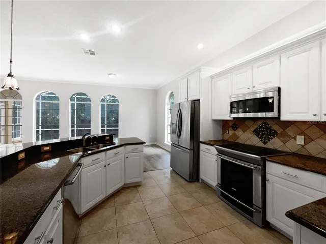 a large kitchen with a stove a sink and a refrigerator