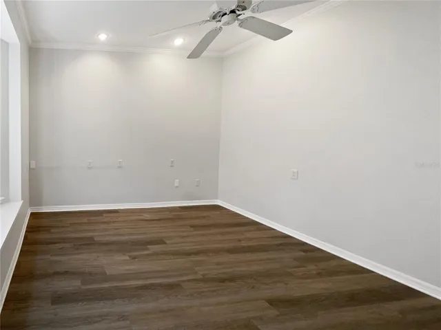 a view of an empty room with wooden floor