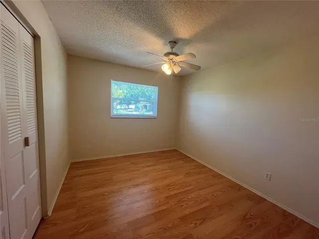 an empty room with a fan and a fan