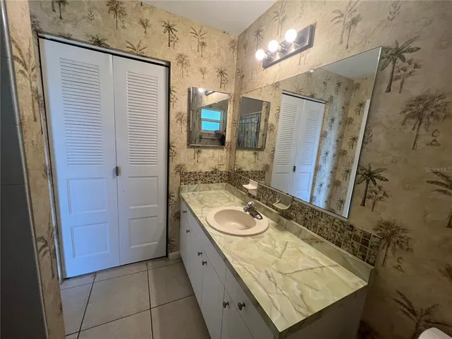 a bathroom with a granite countertop sink mirror vanity and toilet