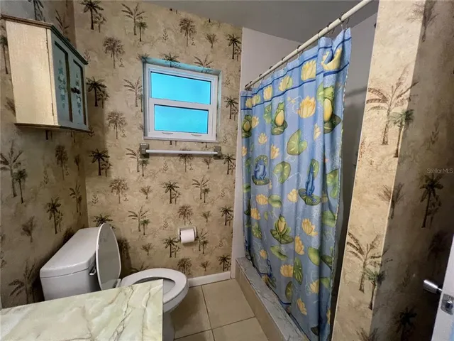 a view of a room with wooden floor and a ceiling fan
