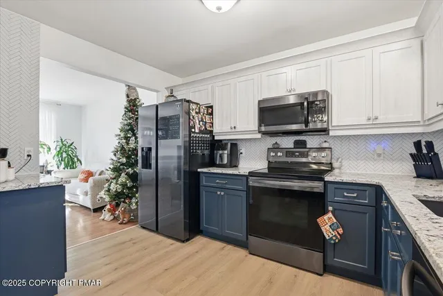 a kitchen with stainless steel appliances granite countertop a stove top oven a sink dishwasher a refrigerator and a microwave