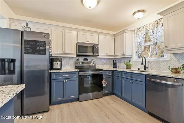 a kitchen with stainless steel appliances granite countertop a stove sink and cabinets