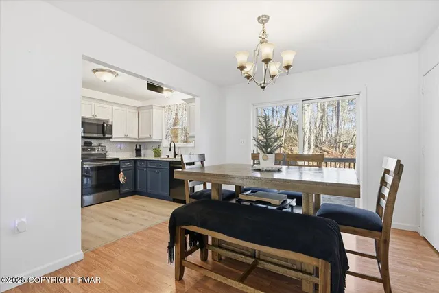 a dining room with furniture a chandelier and wooden floor