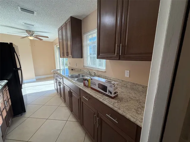 a kitchen with granite countertop a sink stove and refrigerator