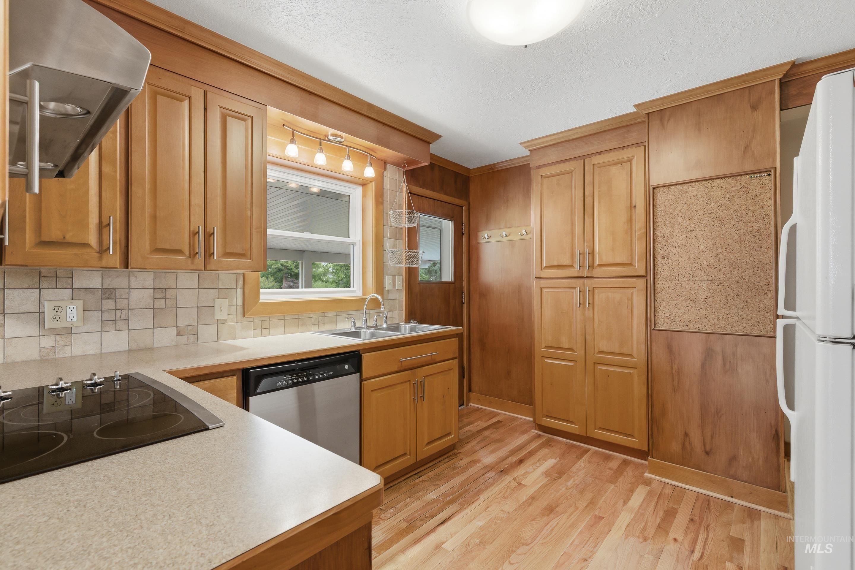 504 West Howe Street Boise, ID 83706 - Photo 17 of 47 Kitchen featuring wood-finish flooring, wood cabinetry, a built-in dishwasher, and a stainless steel range hood