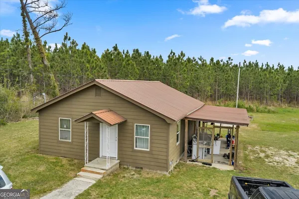 a aerial view of a house with yard porch and furniture